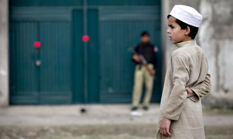 A boy stands in front of the front gates of the compound, where US Navy SEAL commandos reportedly killed Al Qaeda leader Osama bin Laden, in Abbottabad. —Photo by Reuters