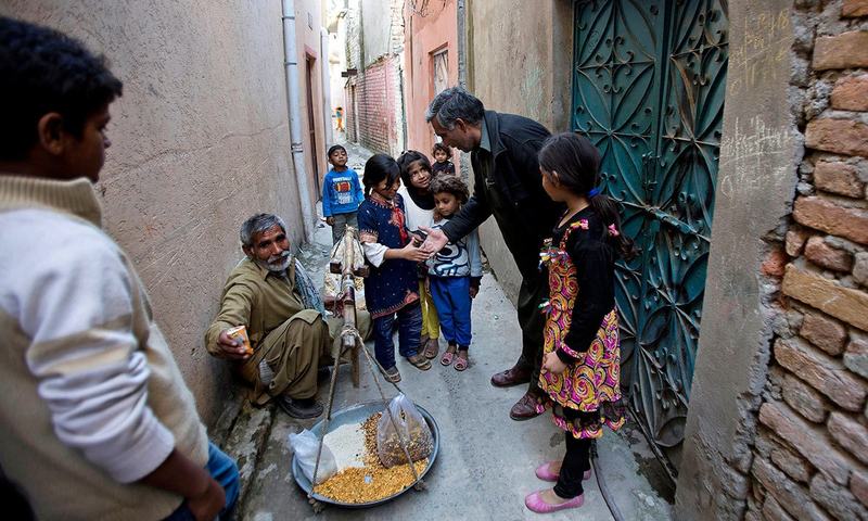 محمد ایوب ایک کچی بستی میں بچوں سے ملتے ہوئے &mdash; اے پی فوٹو