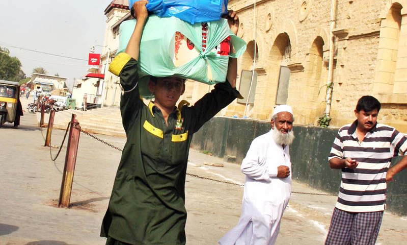 A porter seen carrying luggage of passengers as he wears his new uniform. —Online