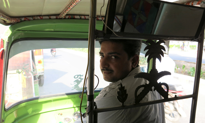 A rickshaw driver in Lahore. — Reuters