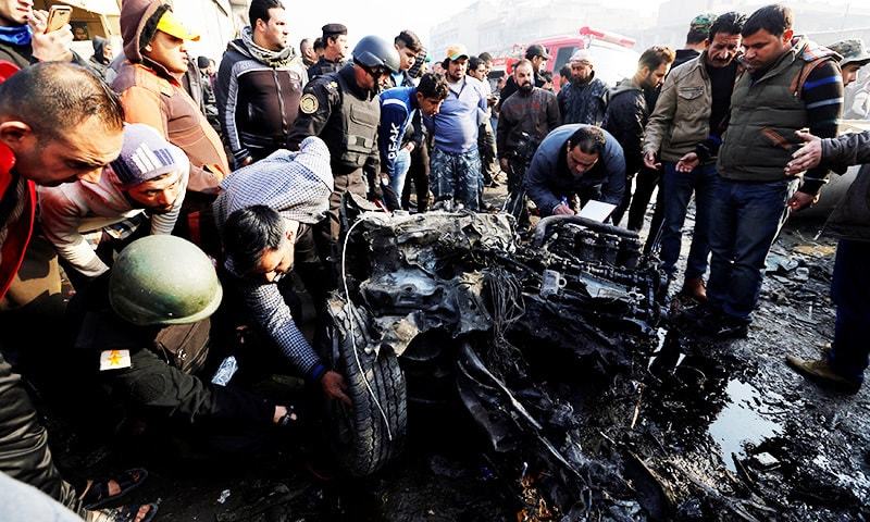 People inspect the site of a car bomb attack at a vegetable market in eastern Baghdad, Iraq.—Reuters