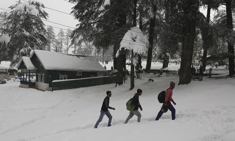 People walk through a snow-covered pathway at Patnitop in Udhampur district of Jammu and Kashmir state.─AP