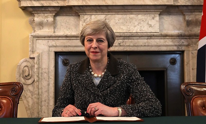 Britain&#39;s Prime Minister Theresa May, signs the official letter to European Council President Donald Tusk, invoking Article 50 and signalling the United Kingdom&#39;s intention to leave the EU, in the cabinet office inside 10 Downing Street.─AFP