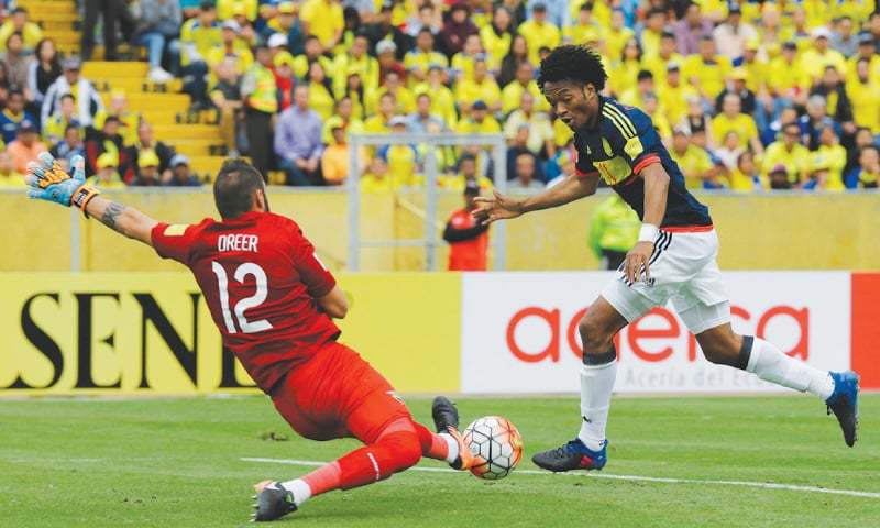 QUITO: Colombia’s Juan Cuadrado dribbles past Ecuador goalkeeper Esteban Dreer to score during the 2018 World Cup qualifier at the Atahualpa Olympic Stadium.—AP