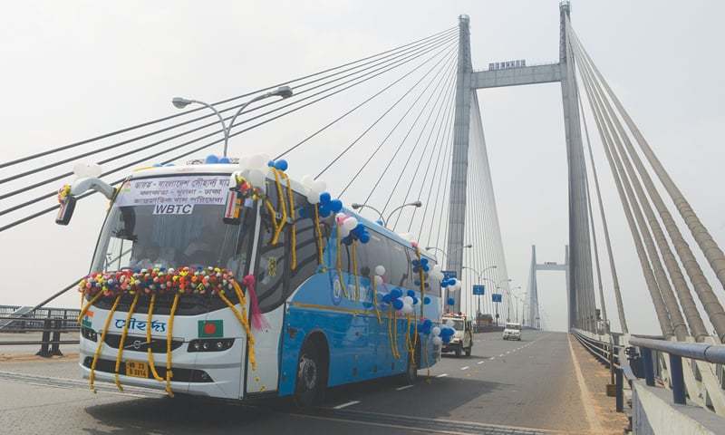 The newly launched Kolkata-Khulna-Dhaka bus drives over the Vibyasagar Setu (bridge) on the River Ganges after it was flagged off in Kolkata on Saturday. Bangladeshi Prime Minister Sheikh Hasina, her Indian counterpart Narendra Modi and West Bengal Chief Minister Mamata Banerjee inaugurated the bus service remotely from New Delhi.—AFP