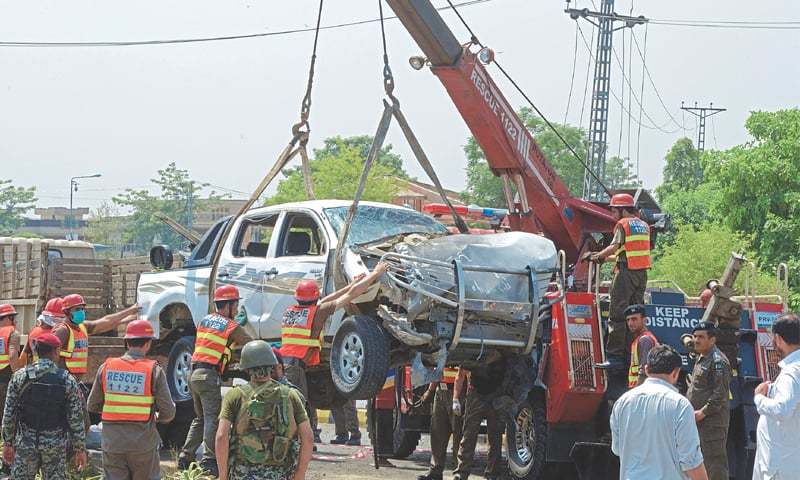 Peshawar Officials use a crane to lift a security vehicle at the site of a suicide bomb attack on Monday. A military officer was martyred and 10 other people were injured when a suicide bomber struck the vehicle carrying personnel of the Frontier Corps