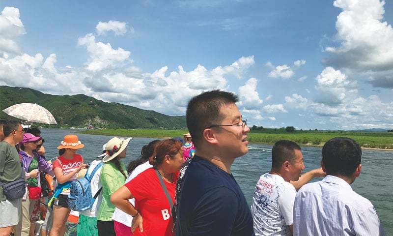 Dandong: Chinese tourists are seen on a boat taking them from the Chinese side of the Yalu River for sightseeing close to the shores of North Korea on Thursday.—Reuters