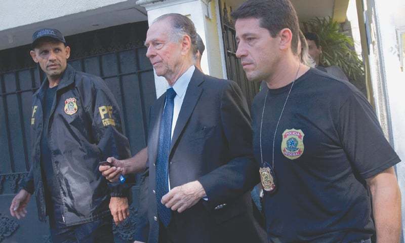 RIO DE JANEIRO: Brazilian Olympic Committee president Carlos Nuzman is escorted by federal police officers after being taken into custody at his home on Thursday.—AP
