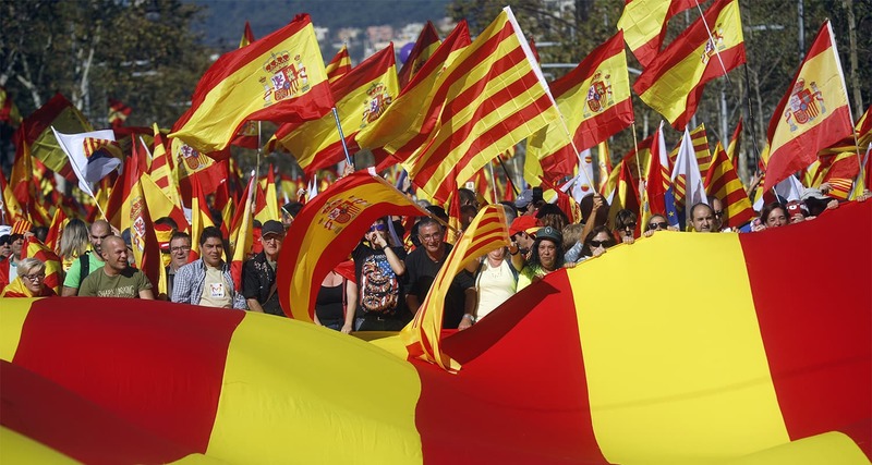 Nationalist activists protest with Spanish and Catalan flags during a mass rally against Catalonia's declaration of independence, in Barcelona.─AP