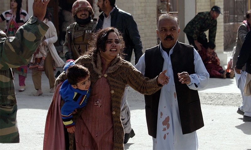 A man helps an injured woman and a child following an attack. —AP