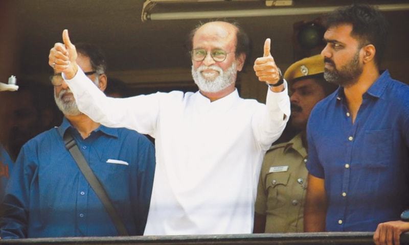 INDIAN movie superstar Rajinikanth (centre) gives thumbs up sign to his fans after announcement about the launch of his own political party in Chennai on Dec 31, 2017.—ANN
