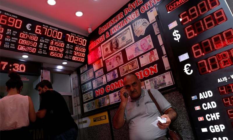 ISTANBUL People change money at a currency exchange office on Friday.—Reuters