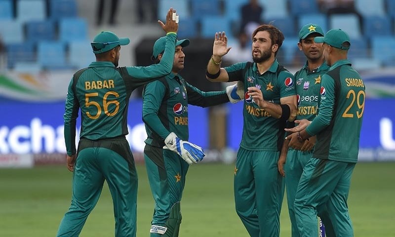 Usman Khan (C) celebrates with teammates after he dismissed Hong Kong batsman Scott McKechnie — AFP