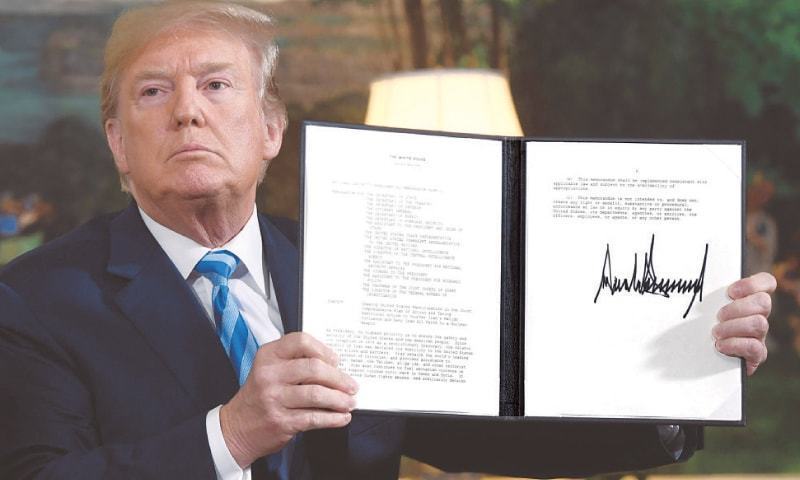 President Trump shows a document which he signed in May to pull US out of the Iran deal which put curbs on Tehran’s nuclear programme in return for lifting of sanctions. — File AFP