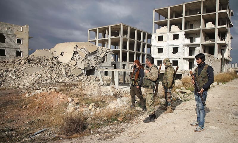 Syrian rebel-fighters from the National Liberation Front (NLF) inspect the rubble of a building destroyed by a reported air strike from the day before in the rebel-held al-Rashidin district of western Aleppo's countryside near Idlib province, on November 26, 2018. —AFP