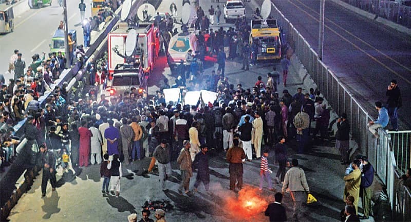 Family members and neighbours of victims who were allegedly killed by the Counter Terrorism Department in Sahiwal block Ferozepur Road in protest against the killings. — White Star
