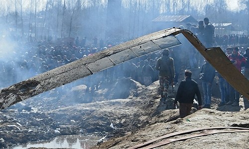 Indian soldiers and onlookers stand near the remains of an Indian Air Force helicopter after it crashed in occupied Kashmir's Budgam district, outside Srinagar on February 27, 2019. — AFP/File
