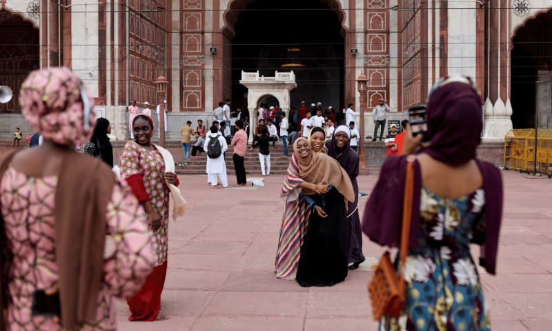 Nigerian Muslim women react as they take pictures at Jama Masjid on the occasion of Eidul Azha, in the old quarters of Delhi, India. &mdash; Reuters