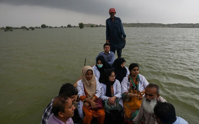 A team of doctors travel to flooded areas in a boat, following rains and floods during the monsoon season, in Manjhand town, in Jamshoro on Monday. — Reuters