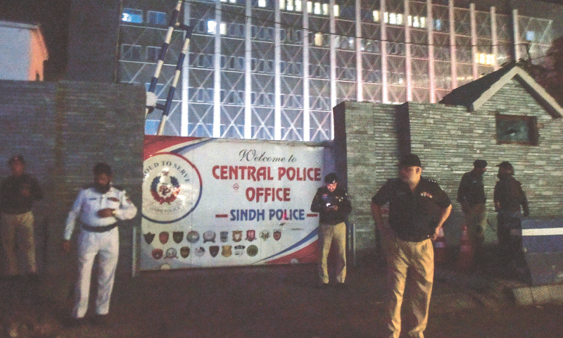 Policemen stand guard outside the Central Police Office on Friday evening. Security was beefed up on important installations following the armed assault on the Karachi Police Office.— Fahim Siddiqi / White Star