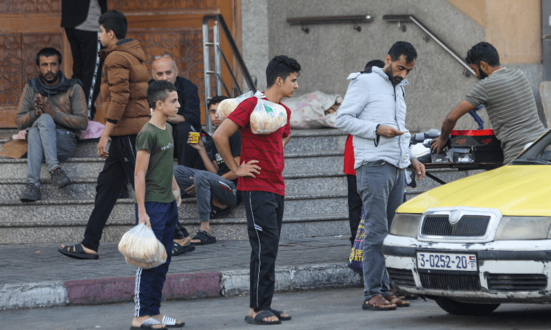 Palestinians buy bread in Gaza City on October 16. &mdash; AFP