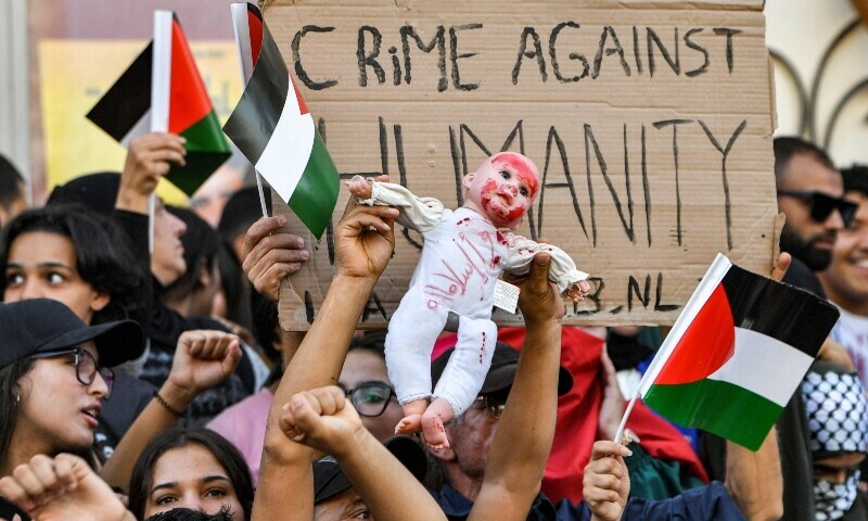 Protesters raise a doll depicting a baby as they chant slogans during an anti-Israel demonstration outside the French embassy headquarters along the Avenue Habib Bourguiba in the centre of Tunis. &mdash; AFP