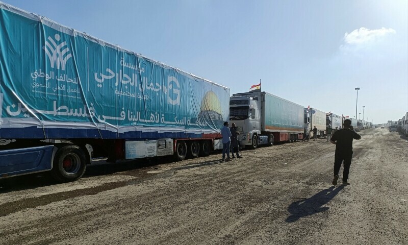 An Egyptian volunteer walks next to trucks carrying humanitarian aid from Egyptian NGOs for Palestinians in Rafah, Egypt October 19. — Reuters