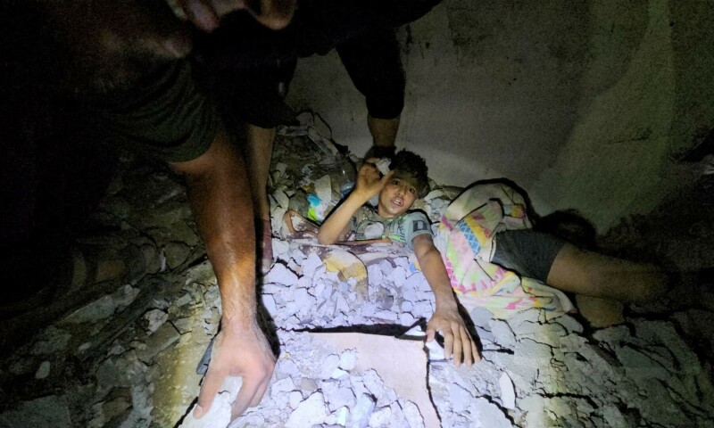 Palestinians work to rescue a boy trapped in the rubble following an Israeli strike on a house in Jabalia in the northern Gaza Strip, October 19. &mdash; Reuters