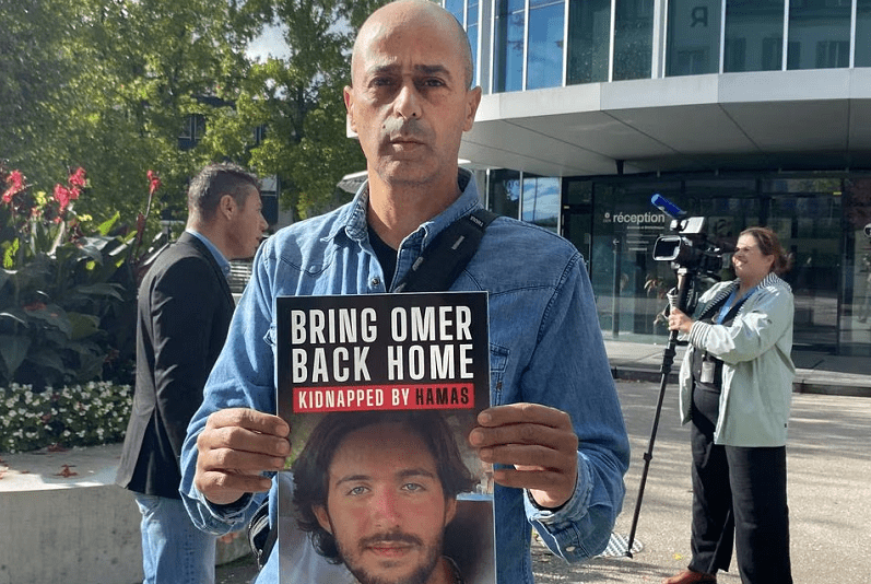 Assaf Shem Tov, uncle of Omer Shem Tov, a hostage taken to Gaza by Hamas, holds a sign calling for his nephew&rsquo;s release in front of ICRC in Geneva. &mdash; Reuters