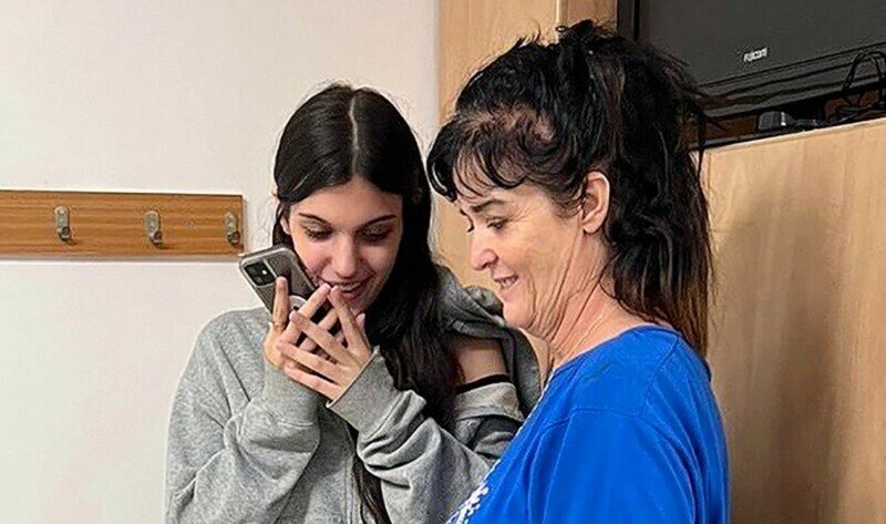 This handout picture courtesy of the United States embassy in Jerusalem taken on October 20, 2023 shows Natalie Shoshana Raanan (L) and Judith Tai Raanan speaking on the phone with US President Joe Biden. &mdash; Reuters