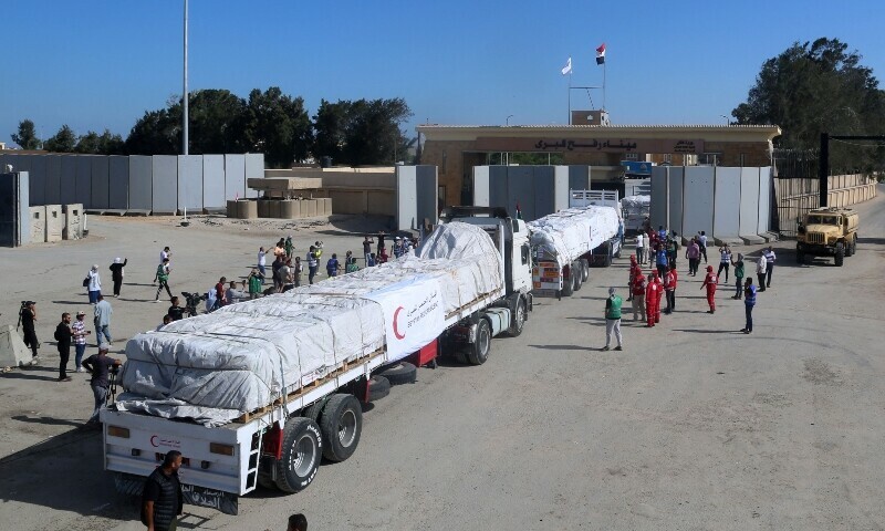 People on the Egyptian side of the Rafah border crossing cheer as a convoy of lorries carrying humanitarian aid crosses to the Gaza Strip on October 21, 2023. &mdash; AFP