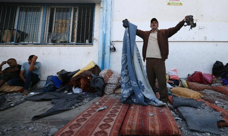 Palestinians react to the debris after an Israeli strike near an United Nations Relief and Works Agency for Palestine Refugees in Khan Yunis. &mdash; AFP