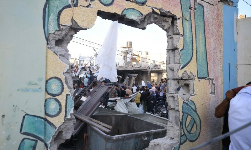 Palestinians inspect the debris after an Israeli strike near an United Nations Relief and Works Agency for Palestine Refugees. &mdash; AFP