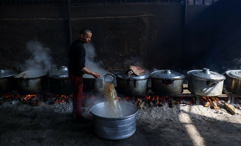Palestinians prepare meals for the UN shelter to be distributed to the displaced in Rafah, on the southern Gaza Strip on October 23, 2023. &mdash; AFP