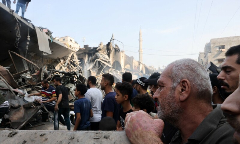  People watch as others sift through the rubble of a destroyed building following Israeli strikes on Al-Shatee camp in Gaza City on October 28. &mdash; AFP 