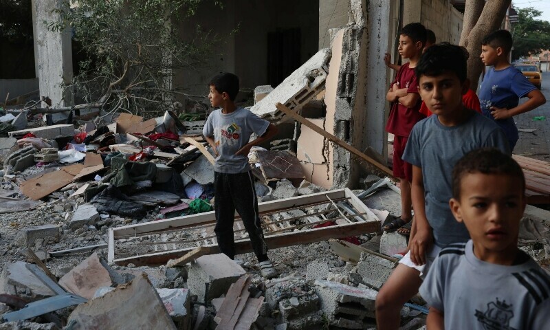 Palestinian boys look at the destroy home of the Kurd family where eight family members were killed in an Israeli airstrike in Gaza. &mdash; AFP
