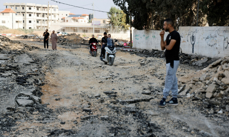 Palestinians drive vehicles along a damaged road, in the aftermath of an Israeli raid, in Jenin refugee camp in the Israeli-occupied West Bank &mdash; Reuters