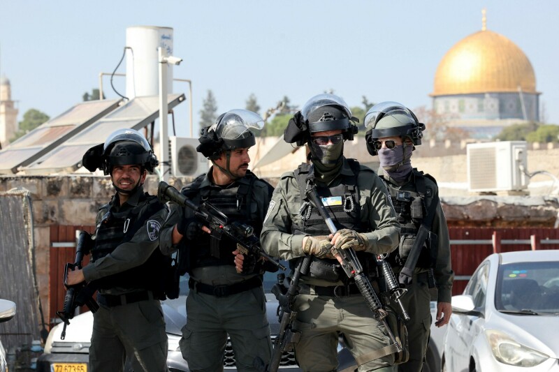 An Israeli security gesture as Muslim Palestinians take part in Friday Noon prayers in East Jerusalem neighbourhood of Ras al-Amud, following age restriction by Israeli security to those above 50-year-old to worshippers wanting to access the Al-Aqsa Mosque compound. &mdash; AFP