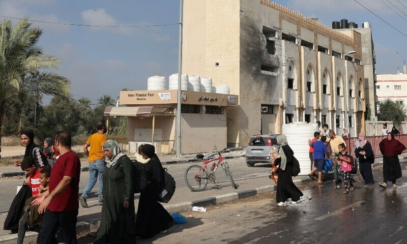 Palestinians walk past a damaged mosque as they flee Gaza City and other parts of northern Gaza towards the southern areas on November 8. &mdash; AFP