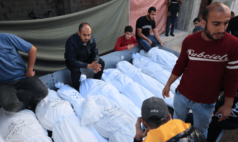  Palestinian members of the Hijazi family, killed after their home was hit during the Israeli bombardment at dusk the evening before, are placed in the back of a pick-up truck to be taken for burial from the Najjar hospital in Rafah in the southern Gaza Strip on Nov 10, 2023. &mdash; AFP 
