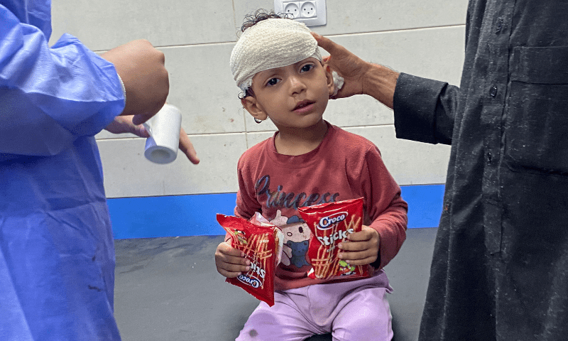  Palestinian girl Orheen Al-Dayah, who was injured on her forehead in an Israeli strike is assisted after she had her wounds stitched without anaesthesia, at Al Shifa hospital in Gaza City, on Nov 8, 2023. — Reuters 