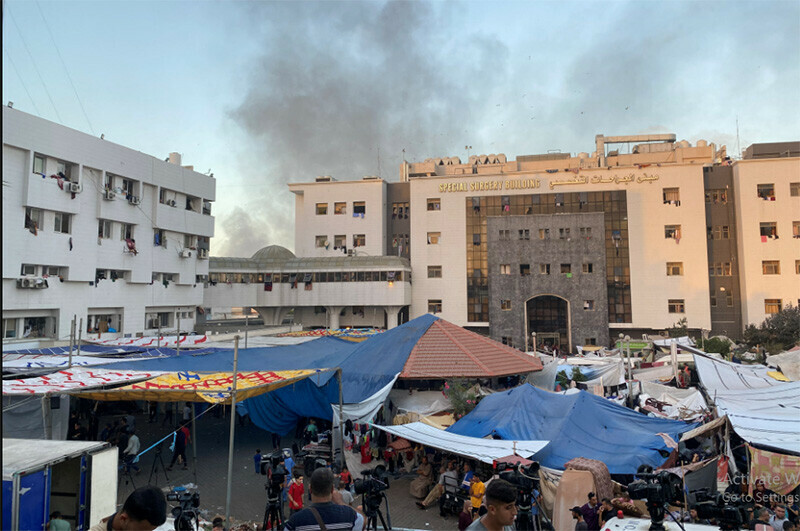 Smoke rises as displaced Palestinians take shelter at Al-Shifa hospital. &mdash; Reuters