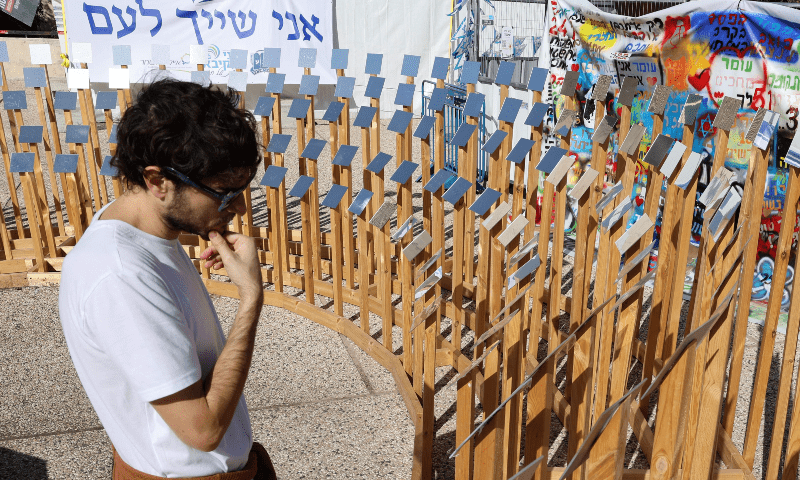  A man stares at an installation in Tel Aviv bearing the names of people taken hostage by Hamas during the October 7 attack, on Nov 24, 2023. &mdash; AFP