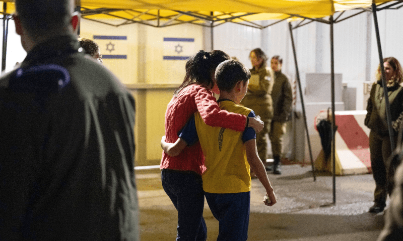 Eitan Yahalomi, 12, walks with his mother at the Kerem Shalom border crossing, after being released from Gaza by Hamas, in Israel, in this handout image obtained by Reuters on Nov 28, 2023. — IDF via Reuters