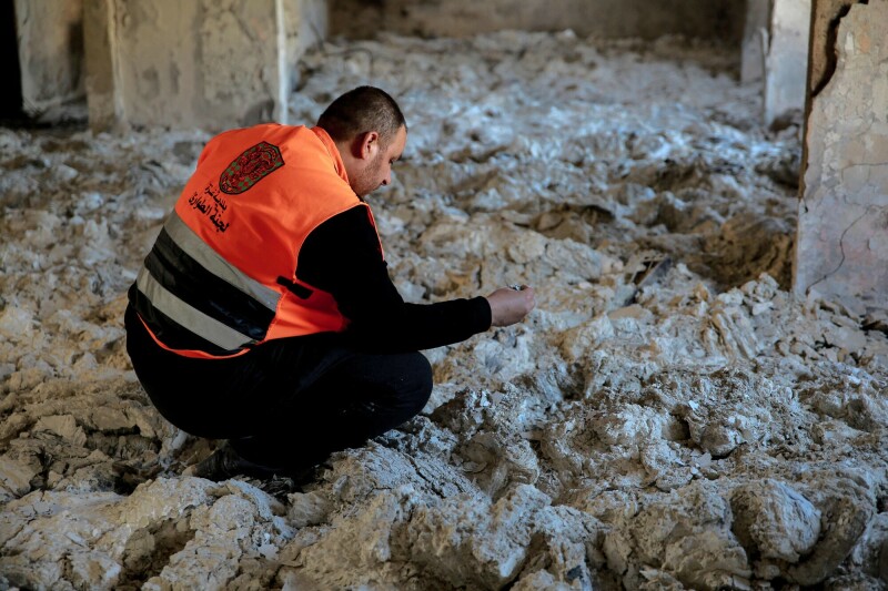 A Palestinian civil defence worker checks documents reduced to ashes, inside the archives department of the Gaza municipality building in Gaza City on November 30. &mdash; AFP