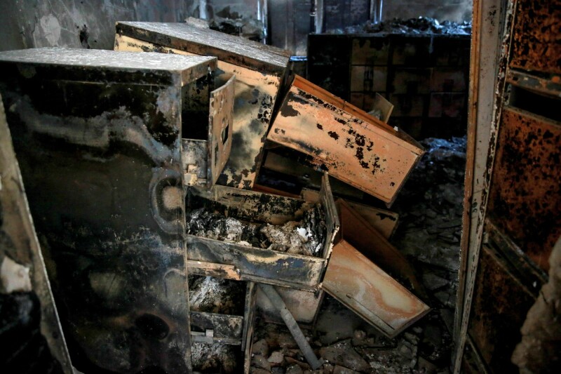 Documents reduced to ashes are scattered inside the archives department of the Gaza municipality building in Gaza City on November 30. &mdash; AFP