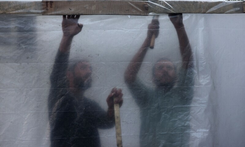 Displaced Palestinians set up shelters in the courtyard of a government-run school in Rafah in the southern Gaza Strip. &mdash; AFP