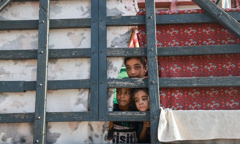 Displaced Palestinian children look out from a makeshift shelter in the courtyard of a government-run school in Rafah in the southern Gaza Strip. &mdash; AFP