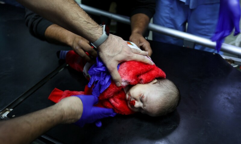 A medical worker assists a wounded Palestinian baby at Nasser hospital following Israeli strikes on December 4, 2023. &mdash; Reuters