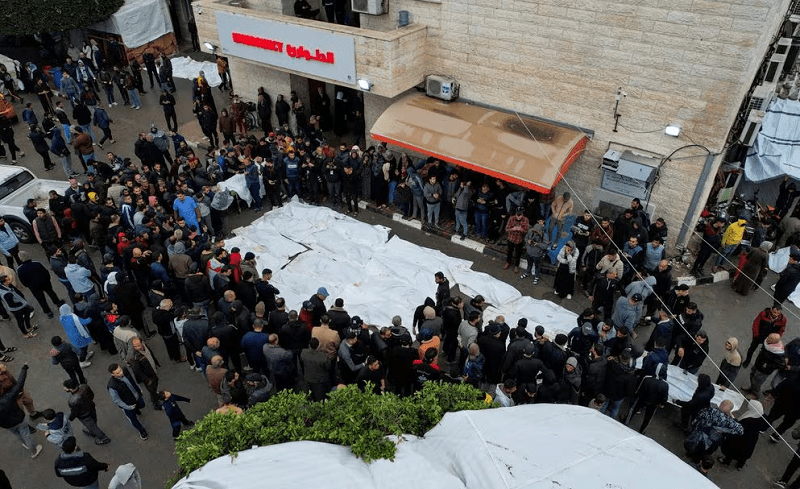 Mourners gather next to the bodies of Palestinians killed in Israeli strikes on December 25, 2023. &mdash; Reuters
